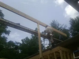 Carpenter setting a ridge beam over a new addition frame — Ice Dam Removal by Roofing Brothers in Lahoma