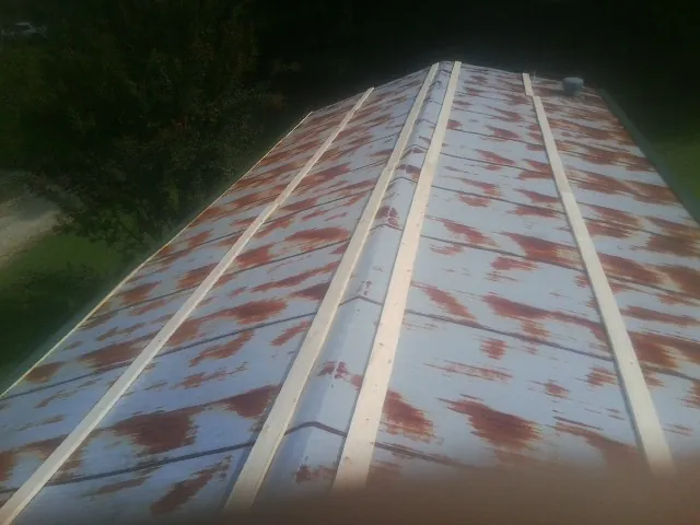 Rusted metal roof panels with new wood purlins before replacement — Storm Damage Roof Repair in Lahoma by Roofing Brothers