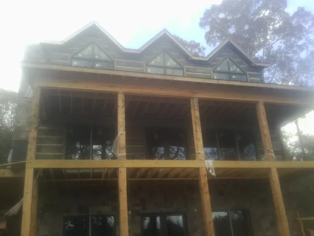Dormers and porch framing on a large log home under construction — Roof Coating work by our crew in Lahoma