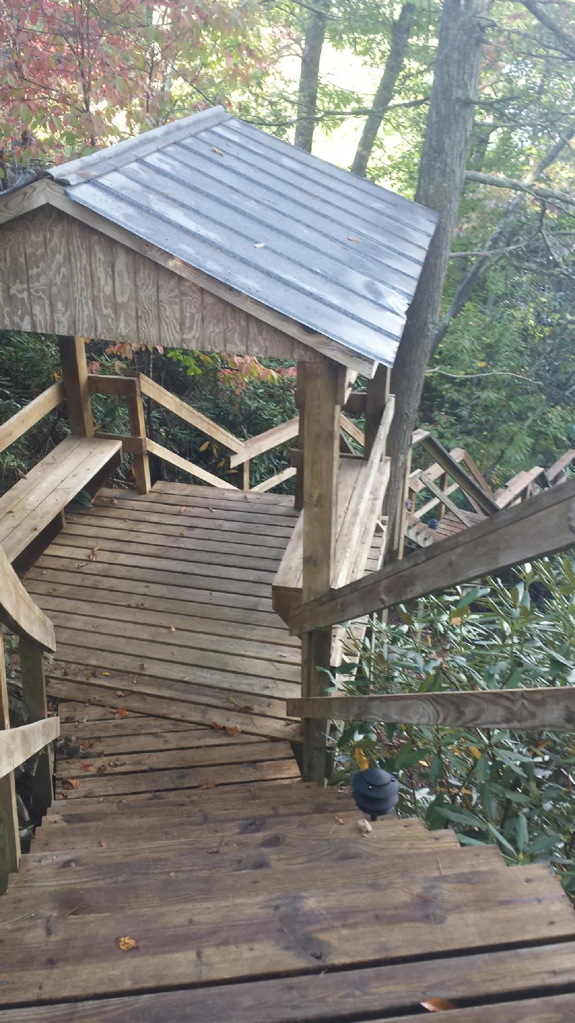 Metal roofed shelter over wooden steps on a wooded walkway — Skylight Repair & Installation work by our crew in Lahoma