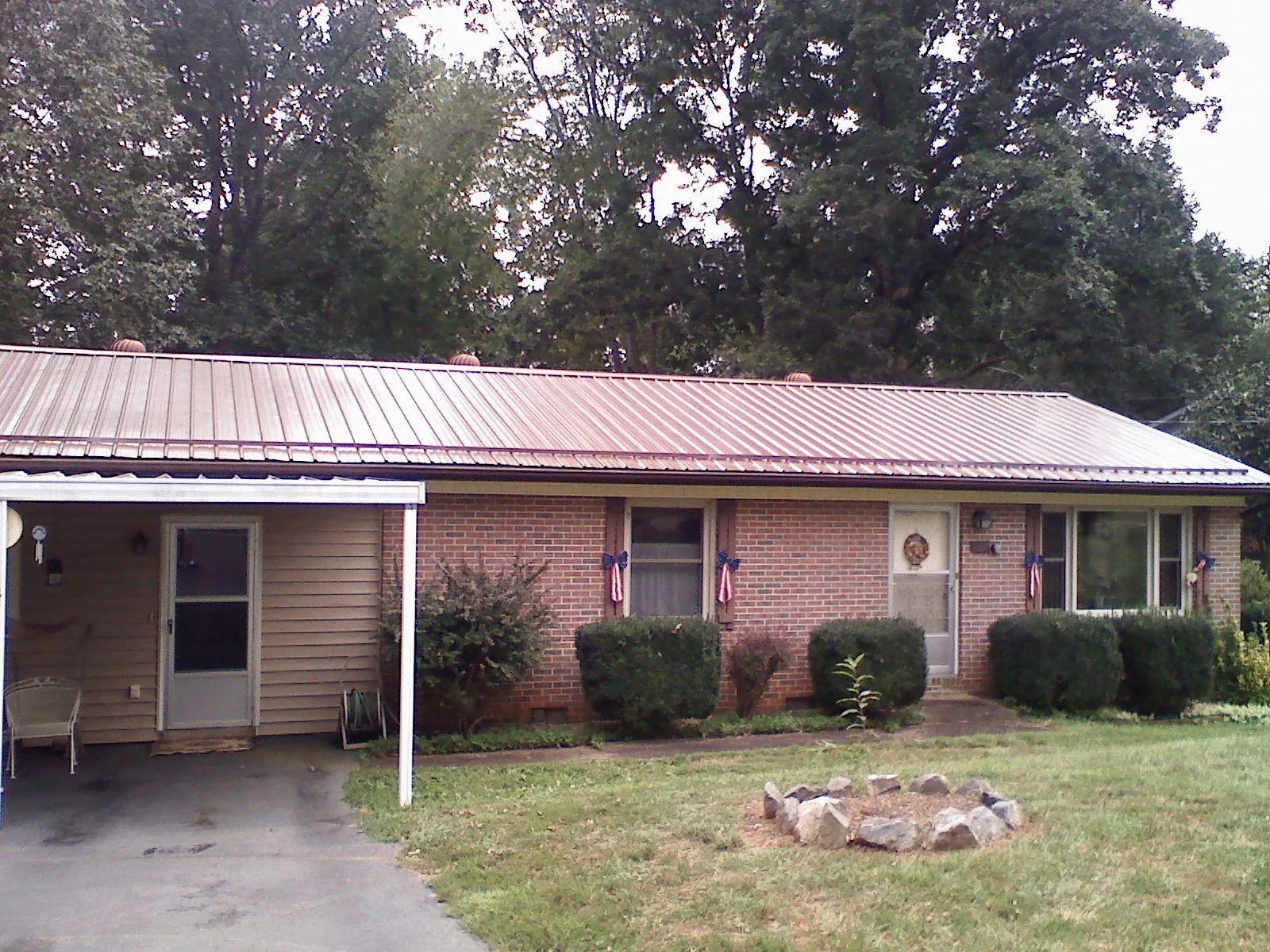 Bronze metal roof and carport on a brick ranch home — Roof Repair work by our crew in Lahoma